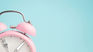Graphic of a pink alarm clock