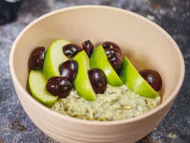 Growli Muesli bowl with sliced applies, sliced cherries, spray cream and optional spices
