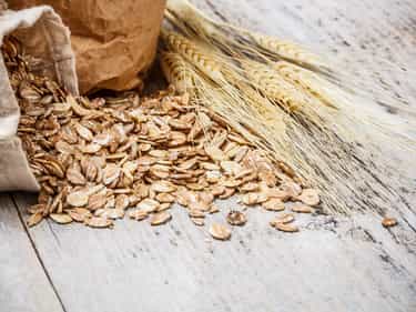 Photo of wheat flakes spilled out onto a wooden surface