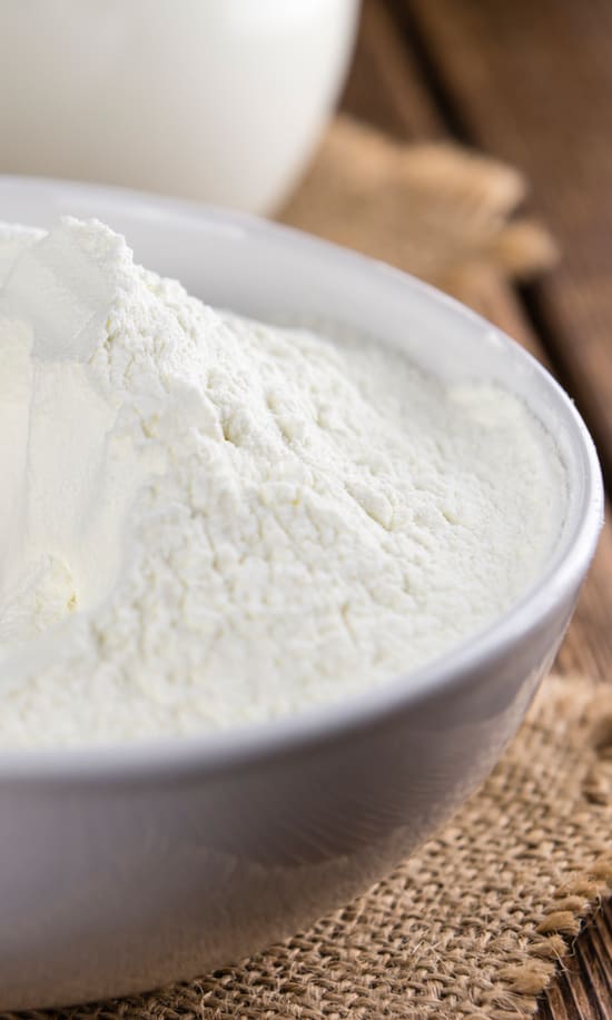 Photo of milk dairy protein powder in a wooden bowl