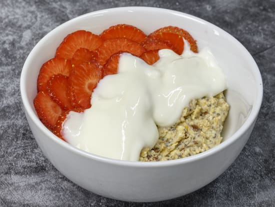 Photo of bowl of Growli Muesli with sliced strawberries and low fat yoghurt