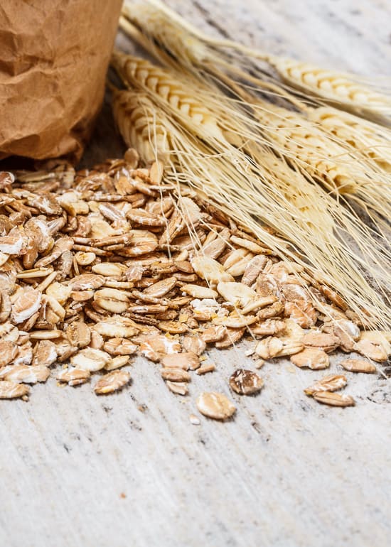Photo of wheat flakes spilled out onto a wooden surface